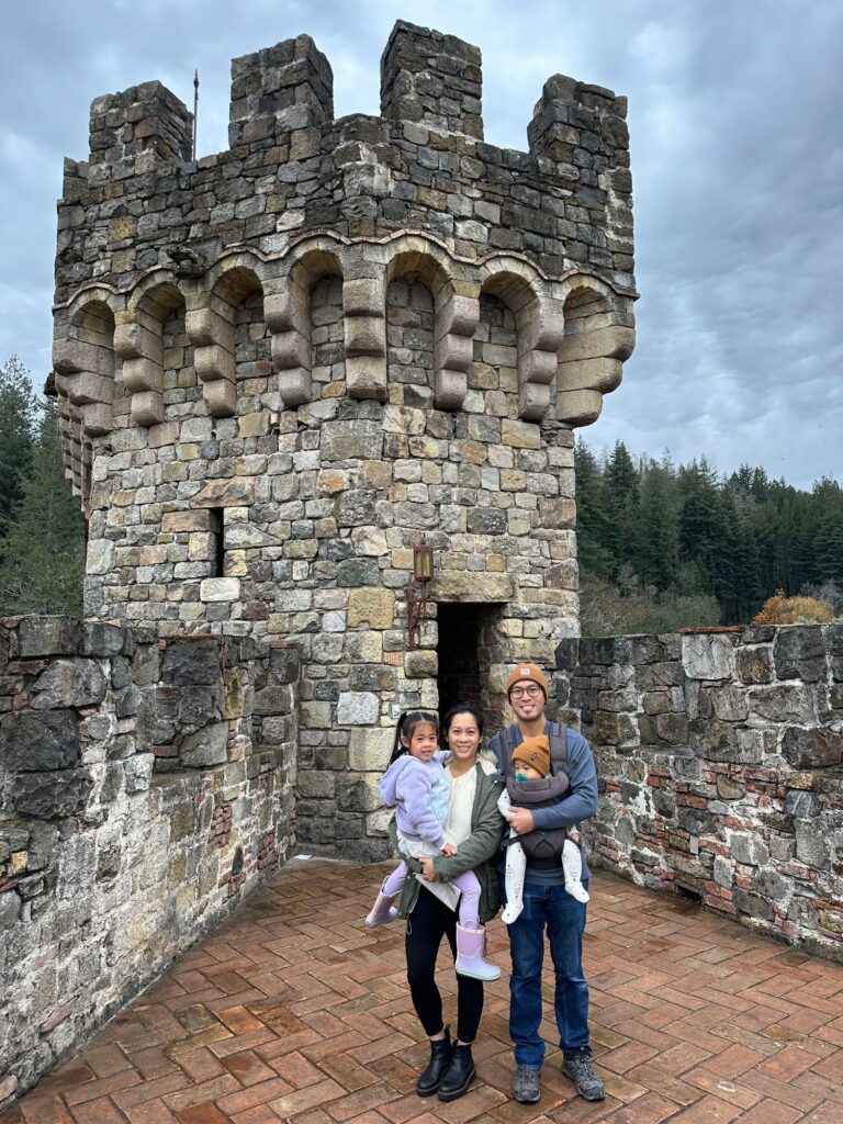 Family standing in front of an old stone tower